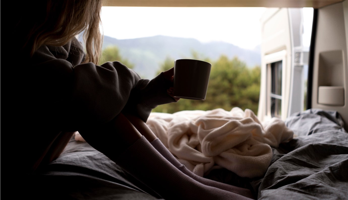 Young woman enjoying her coffee with a view with her RV Loan from Finex Credit Union