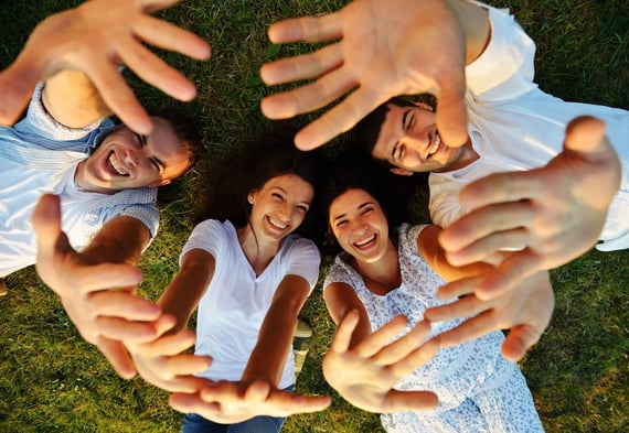 Young cheerful people enjoying on summer meadow