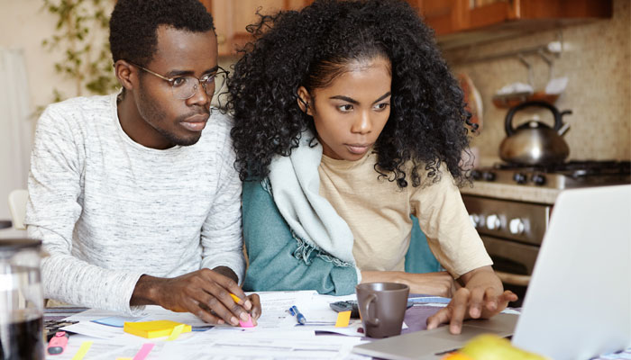  This-couple-is-on-a-laptop-working-through-strategies-to-manage-debt and regain-financial wellness. 