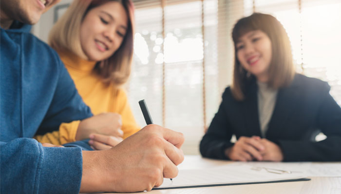 Couple-is-signing-mortgage-paperwork-with-a-mortgage-lender-after-deciding-to-go-with-a-credit-union-as-a-lender-not-a-bank,.