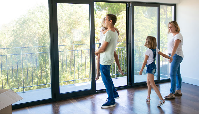  Family-wondering-what-to-look-for-when-buying-a-house-as-they-look-out-a-large-window-of-a-potential-new-home. 