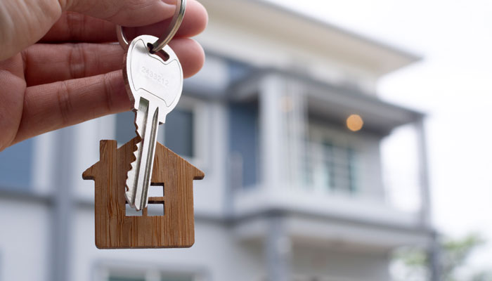 Hand-holding-keys-to-new-house-after-their-home-loan-was-approved.