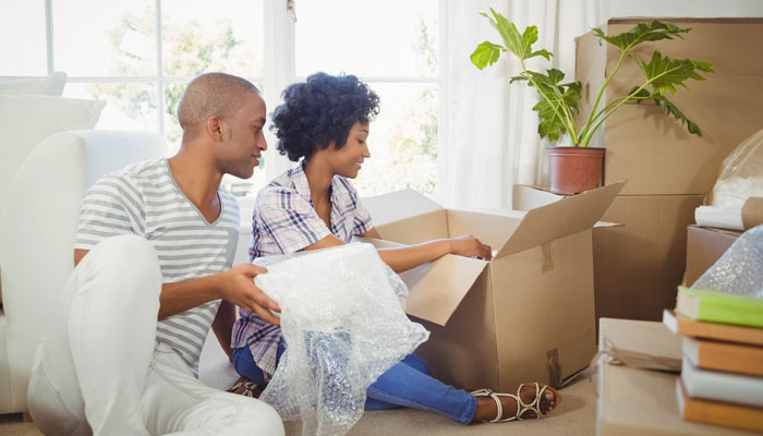 Young-couple-unpacking-moving-boxes-after-their-FHA-Loan-helped-secure-their-first-mortgage.